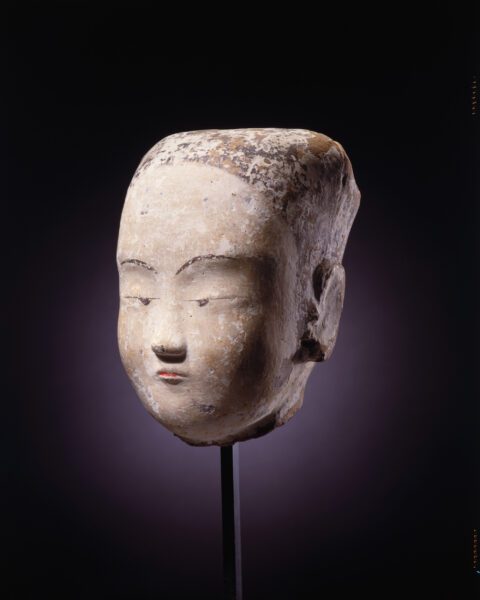 A painted pottery head of a young woman