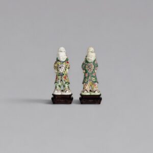 A pair of famille-verte biscuit-glazed piggyback boys