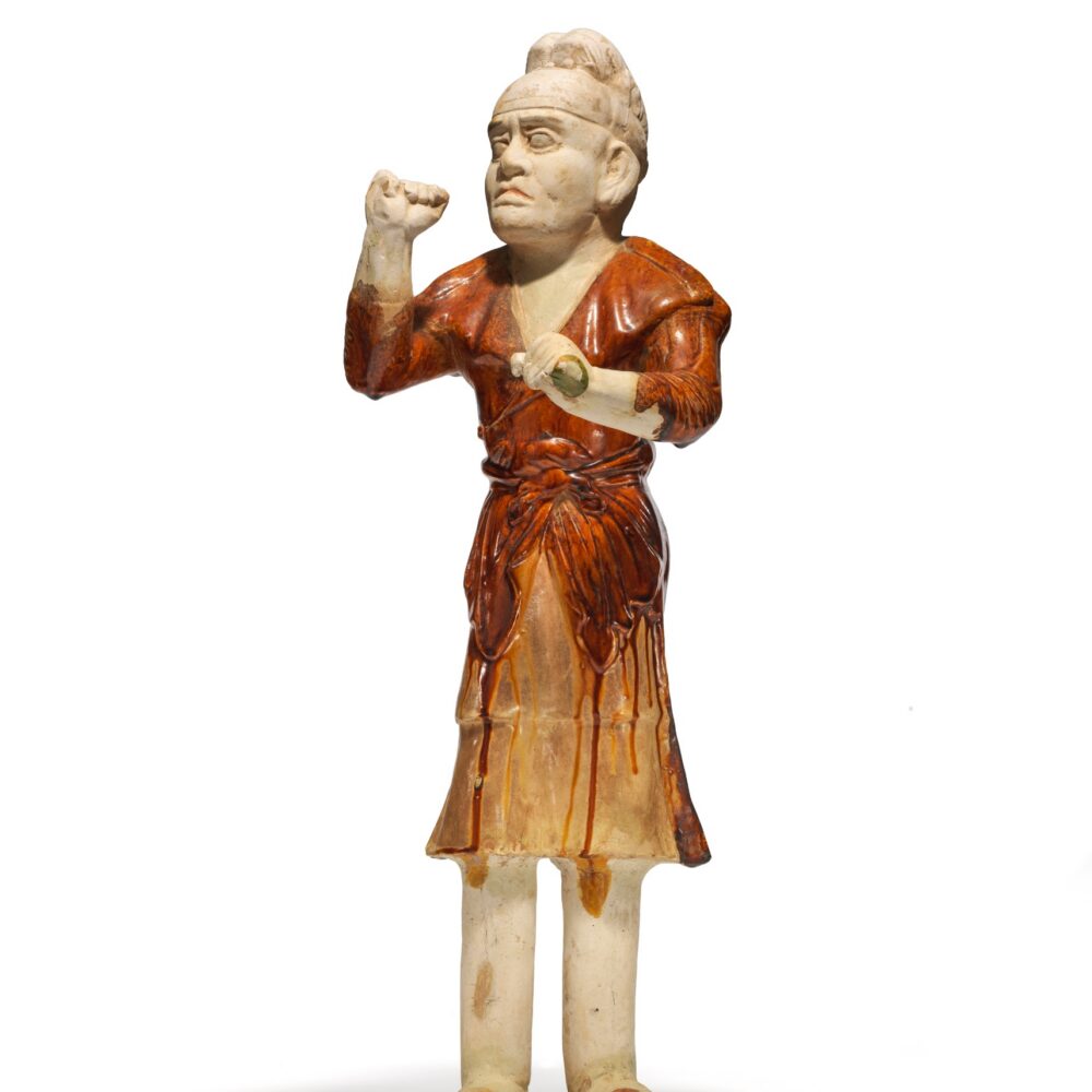 An amber and cream-glazed pottery figure of a groom